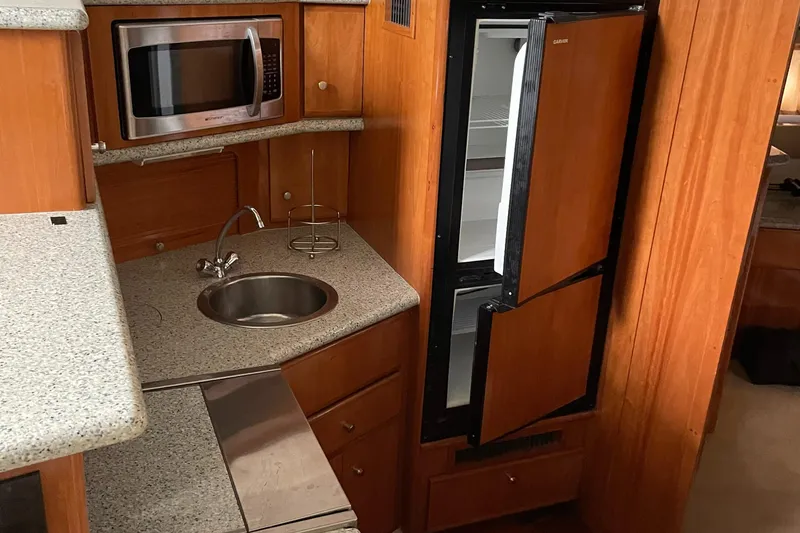 Slide: The Image of 2001 Carver 356 Aft Cabin Motor Yacht kitchen with microwave, sink, and refrigerator. - 18