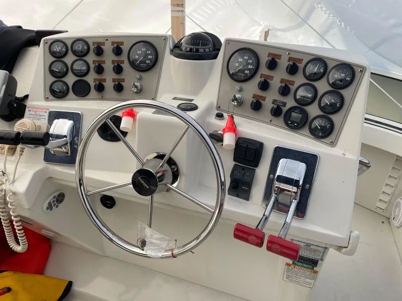 Slide: The Image of Control panel of a 2001 Carver 356 Aft Cabin Motor Yacht with steering wheel and gauges. - 7