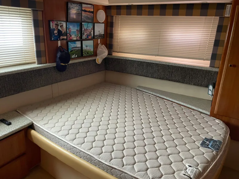 Slide: The Image of 2001 Carver 356 Aft Cabin Motor Yacht bedroom with mattress, framed photos, and blinds. - 10