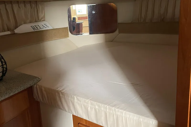 Slide: The Image of 2001 Carver 356 Aft Cabin Motor Yacht interior with cozy bed and mirror. - 16