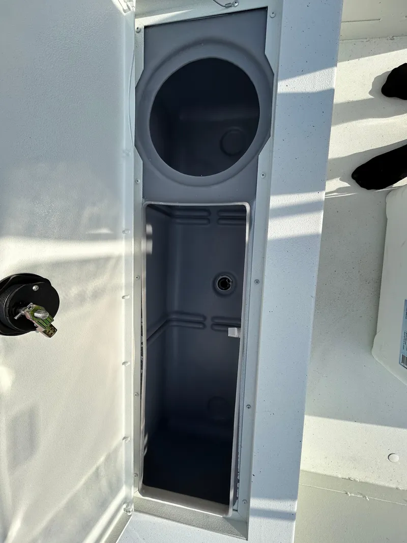 Slide: The Image of 2025 Crestliner 2000 Bay boat storage compartment with cup holder, open view. - 13