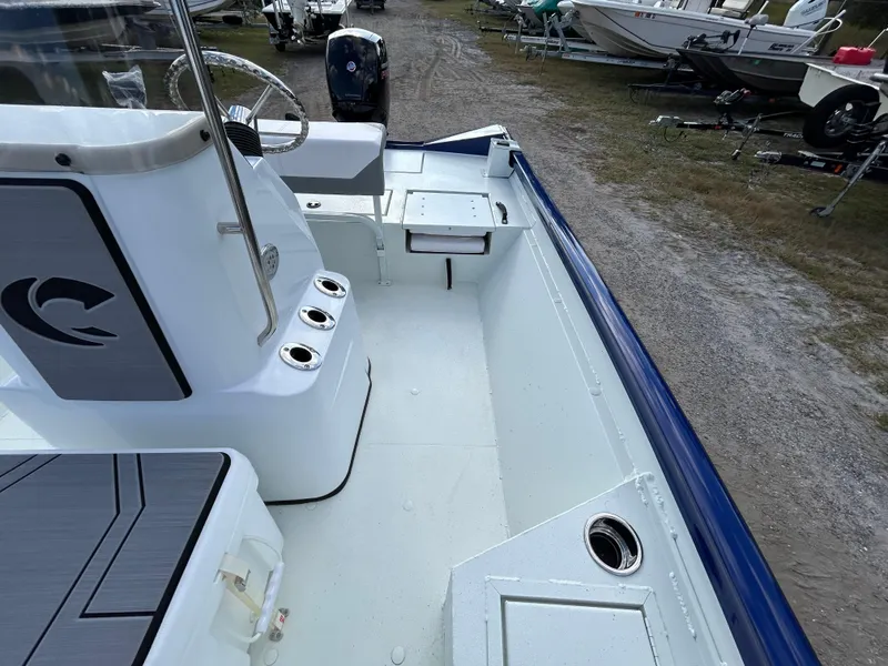 Slide: The Image of 2025 Crestliner 2000 Bay boat interior with steering console and seating, parked on gravel. - 18