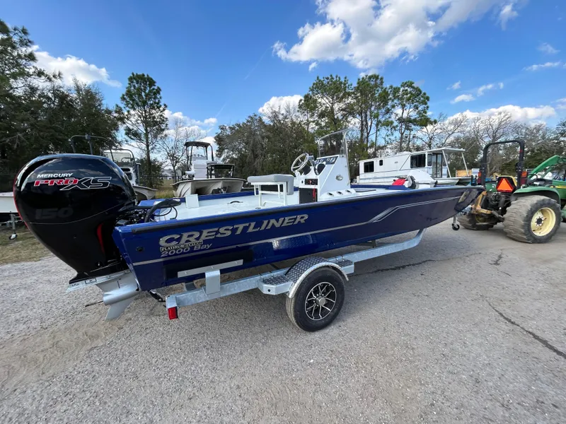 Slide: The Image of 2025 Crestliner 2000 Bay boat on trailer, outdoors under blue sky. - 5