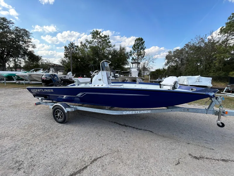 Slide: The Image of 2025 Crestliner 2000 Bay boat on trailer, parked outdoors under a clear sky. - 7