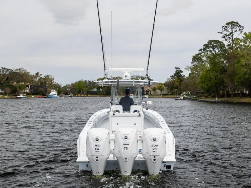 Slide: The Image of 2022 Contender 35ST boat with triple 300 V6 engines cruising on a calm river. - 10