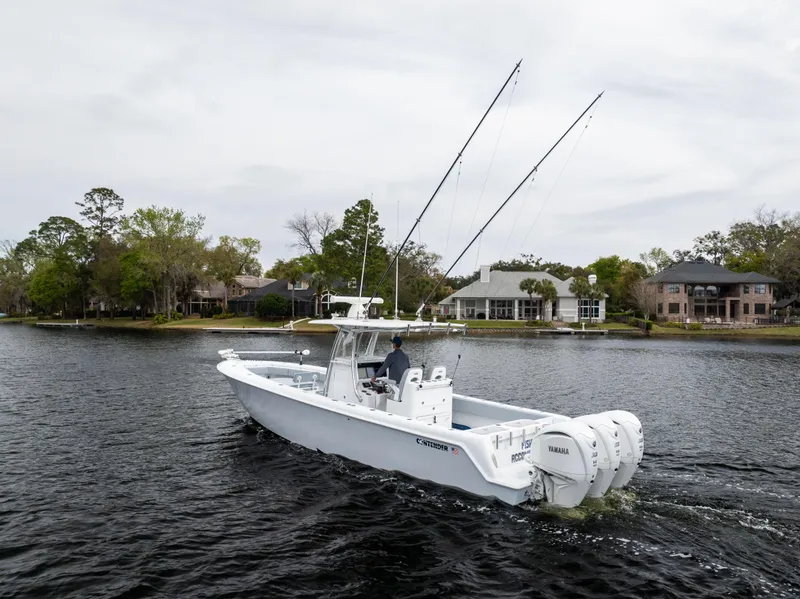 Slide: The Image of 2022 Contender 35ST boat cruising on a calm lake with scenic waterfront homes. - 11