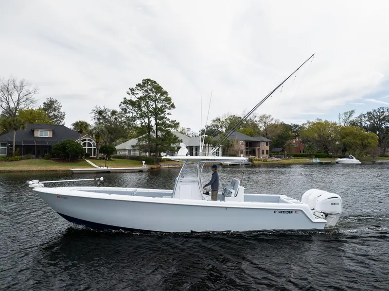 Slide: The Image of 2022 Contender 35ST boat cruising on a calm lake near residential area. - 12