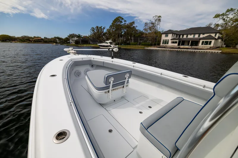 Slide: The Image of 2022 Contender 35ST boat on a serene lake with a luxurious house in the background. - 14