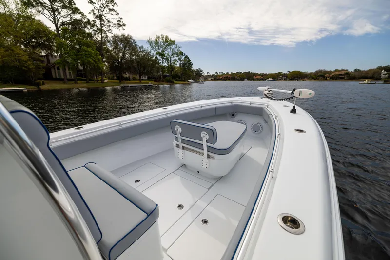 Slide: The Image of 2022 Contender 35ST boat on a calm lake, showcasing spacious deck and seating. - 15