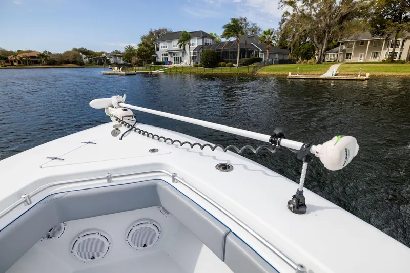 Slide: The Image of 2022 Contender 35ST boat on a serene lake with residential backdrop. - 18