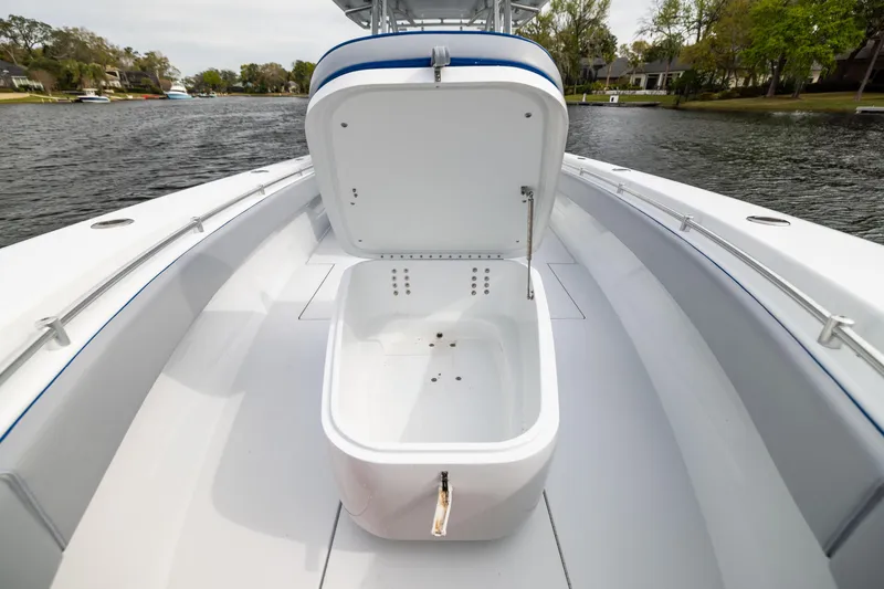 Slide: The Image of 2022 Contender 35ST boat with open storage compartment on a calm river. - 20