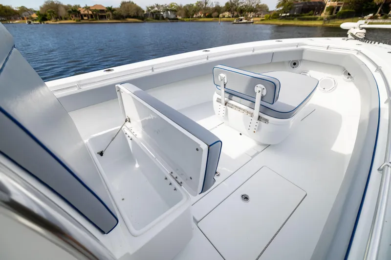 Slide: The Image of 2022 Contender 35ST boat interior with open storage compartments on a calm lake. - 24