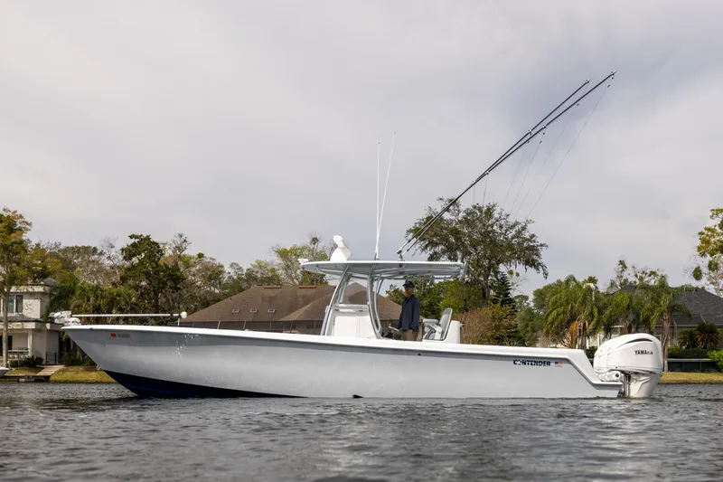 Slide: The Image of 2022 Contender 35ST boat on calm water with fishing rods and Yamaha engines. - 4