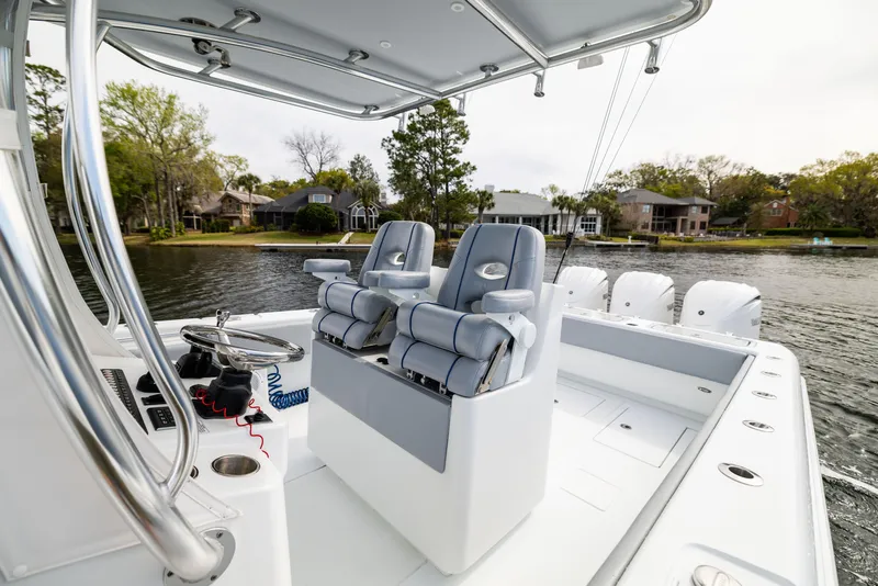Slide: The Image of 2022 Contender 35ST boat interior with dual seats on a calm lake. - 40