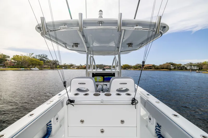 Slide: The Image of 2022 Contender 35ST boat interior with helm, rod holders, and water view. - 46