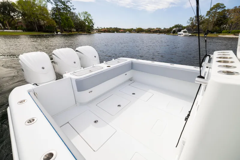 Slide: The Image of 2022 Contender 35ST boat with spacious deck and triple outboard engines on a serene lake. - 47