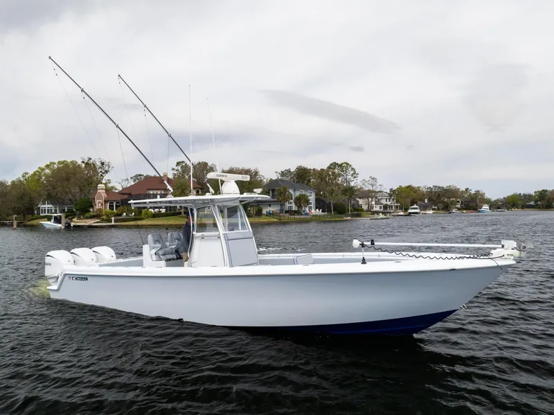 Slide: The Image of 2022 Contender 35ST boat on a calm lake with scenic shoreline. - 7