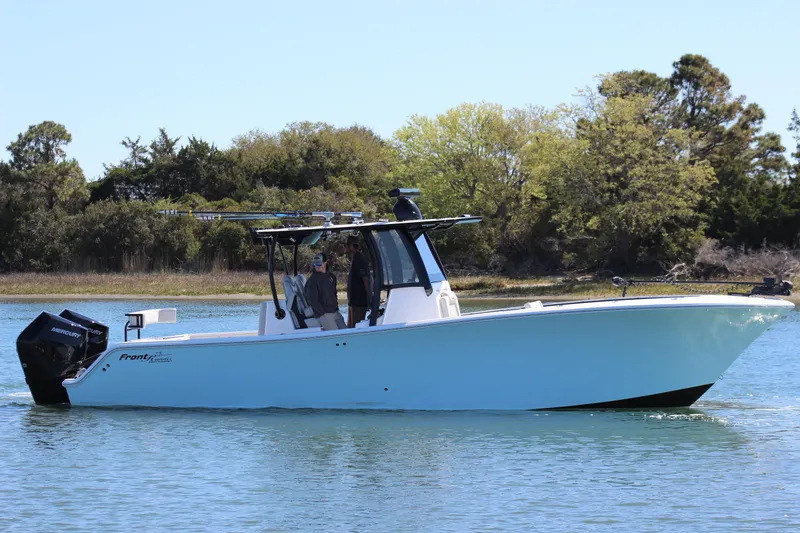 Slide: The Image of 2024 Front Runner 33 Center Console boat on calm water, surrounded by trees. - 0
