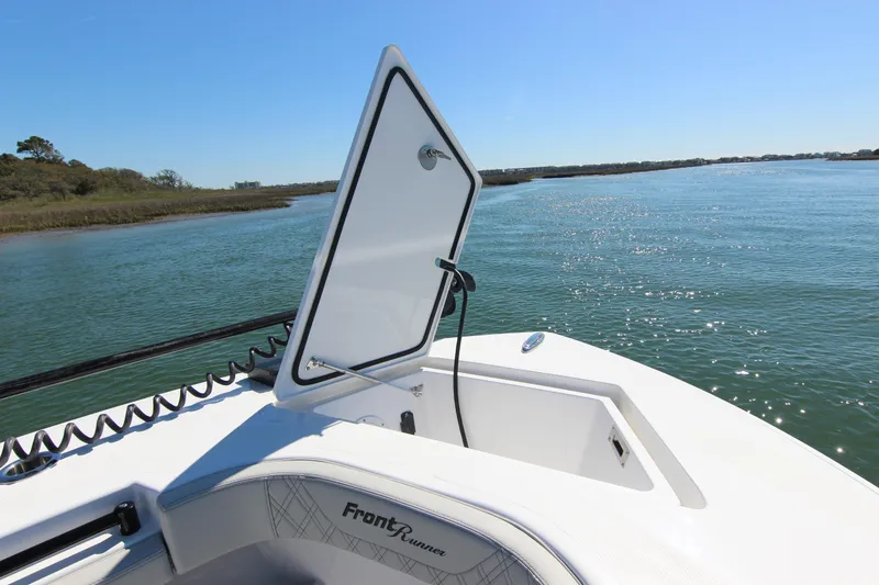 Slide: The Image of 2024 Front Runner 33 Center Console boat on calm water, open storage hatch. - 16