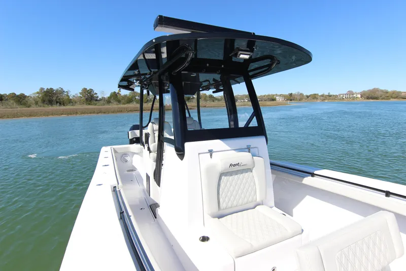 Slide: The Image of 2024 Front Runner 33 Center Console boat on calm water, showcasing sleek design and seating. - 20