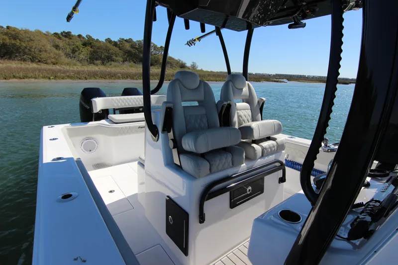 Slide: The Image of 2024 Front Runner 33 Center Console boat interior with plush seating on calm water. - 21