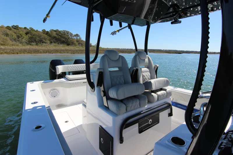 Slide: The Image of 2024 Front Runner 33 Center Console boat with luxurious seating on a serene waterway. - 22