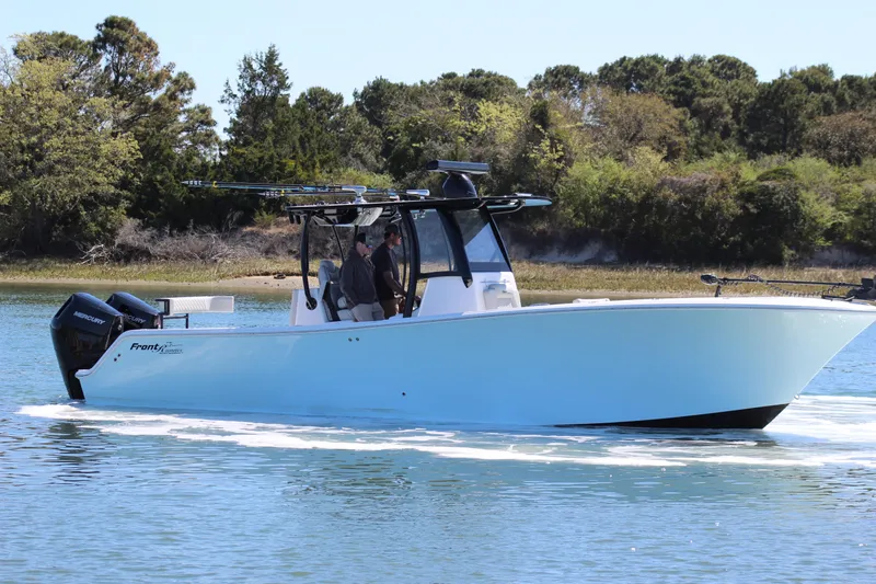 Slide: The Image of 2024 Front Runner 33 Center Console boat cruising on a calm lake with trees in the background. - 5