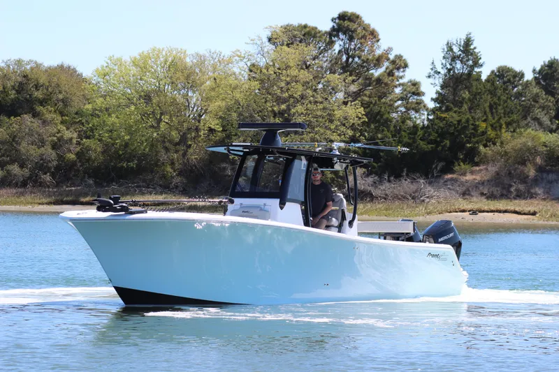 Slide: The Image of 2024 Front Runner 33 Center Console boat cruising on a serene lake. - 8