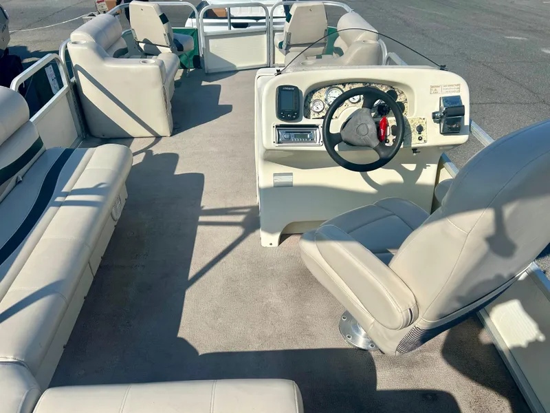 Slide: The Image of 2003 Odyssey Pontoons 2101 Millennium interior with beige seating and steering console. - 10