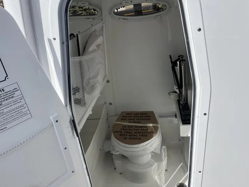 Slide: The Image of 2025 Sea Hunt Ultra 265 SE boat interior with compact marine toilet. - 23
