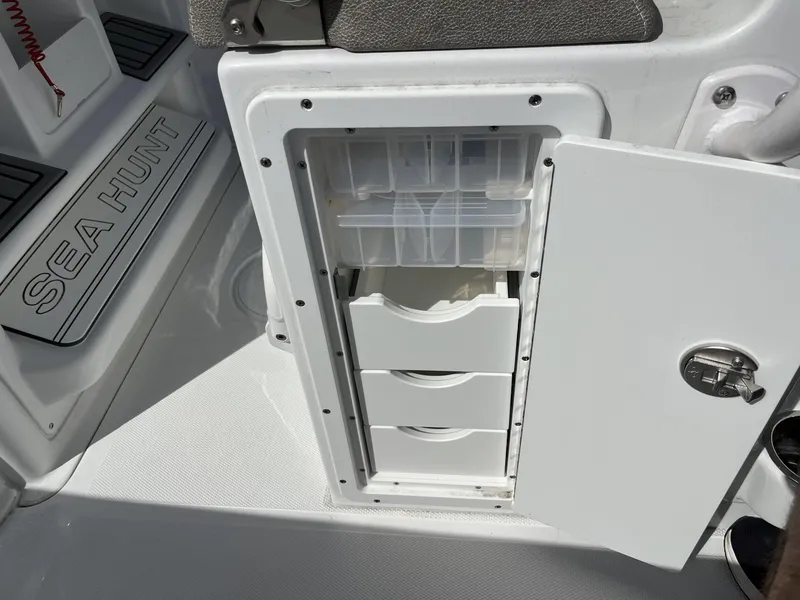 Slide: The Image of Storage compartment on a 2025 Sea Hunt Ultra 265 SE boat, featuring organized drawers. - 33