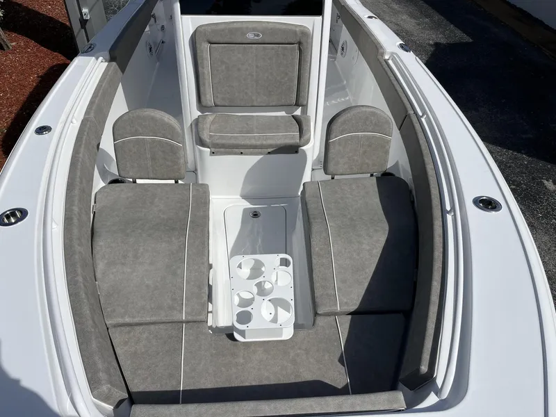 Slide: The Image of 2025 Sea Hunt Ultra 265 SE boat interior with gray cushioned seating and cup holders. - 21
