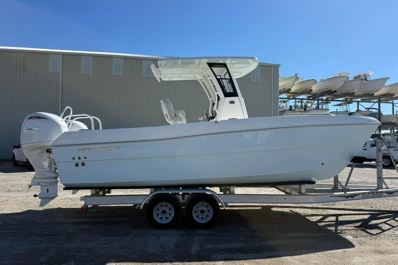Slide: The Image of 2026 World Cat 235 TE boat on trailer, parked outdoors under clear blue sky. - 28