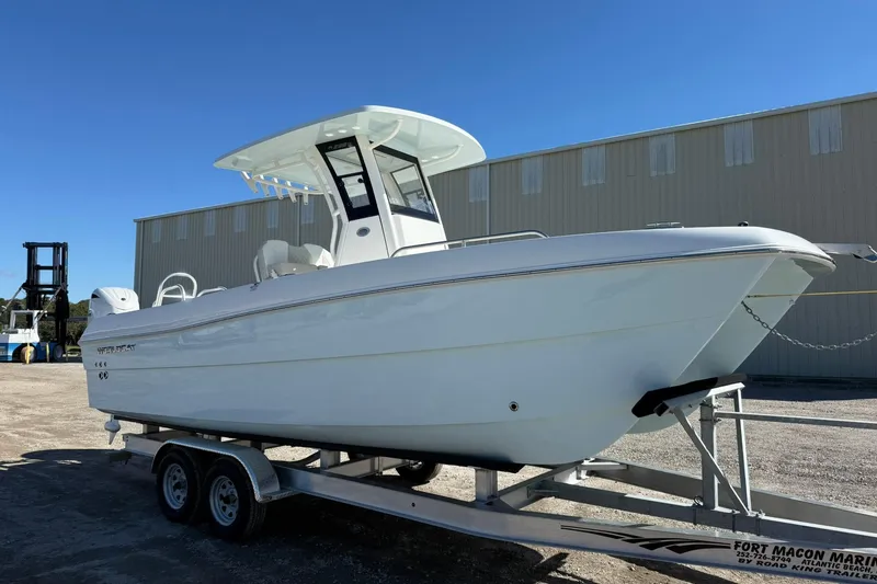 Slide: The Image of 2026 World Cat 235 TE boat on trailer, parked outdoors under clear blue sky. - 29