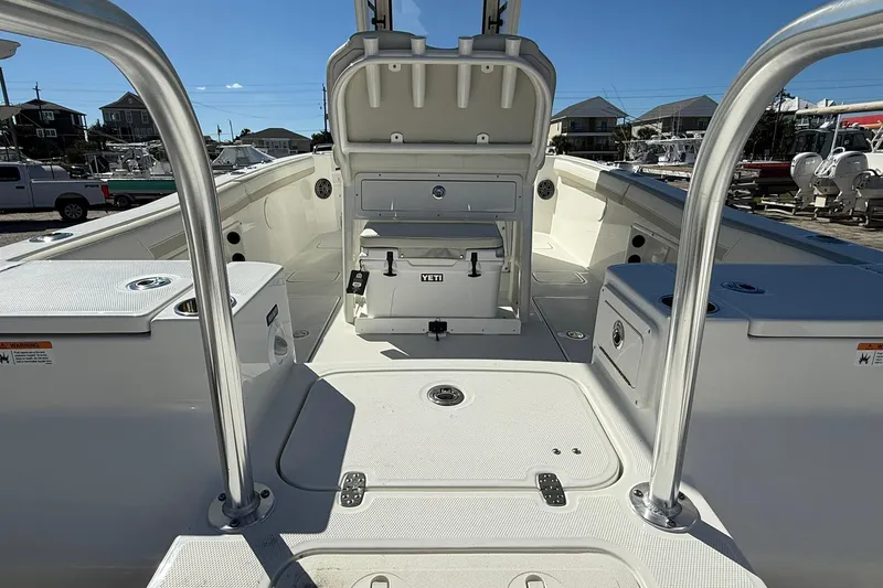 Slide: The Image of 2026 World Cat 235 TE boat interior with seating and storage, docked under clear blue sky. - 33