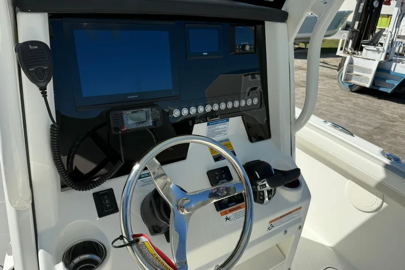 Slide: The Image of 2026 World Cat 235 TE boat dashboard with steering wheel, navigation screens, and controls. - 35