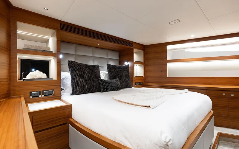Slide: The Image of Luxurious bedroom interior on 2022 Horizon FD 92 yacht, featuring elegant wood finishes and modern design. - 13