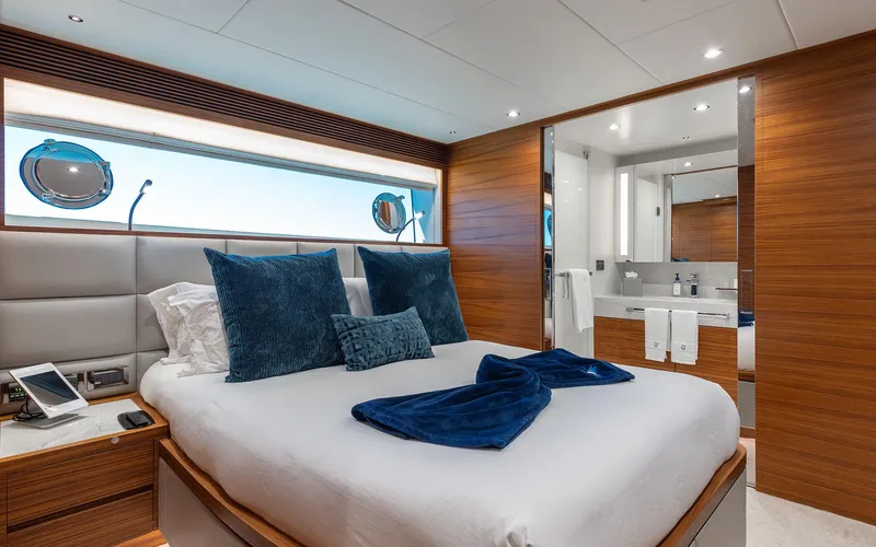 Slide: The Image of Luxurious bedroom on Horizon FD 92 yacht, featuring elegant wood paneling and plush bedding, 2022 model. - 18