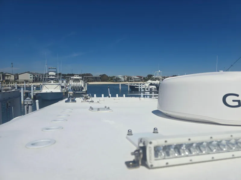 Slide: The Image of 2024 Invincible 43 Open Fisherman boat docked at a marina under clear blue skies. - 15