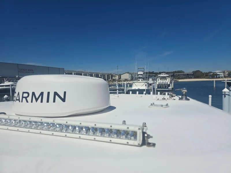 Slide: The Image of 2024 Invincible 43 Open Fisherman boat with Garmin equipment, docked under clear blue sky. - 16