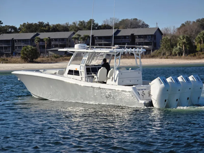 Slide: The Image of 2024 Invincible 43 Open Fisherman boat cruising on water near shoreline. - 19