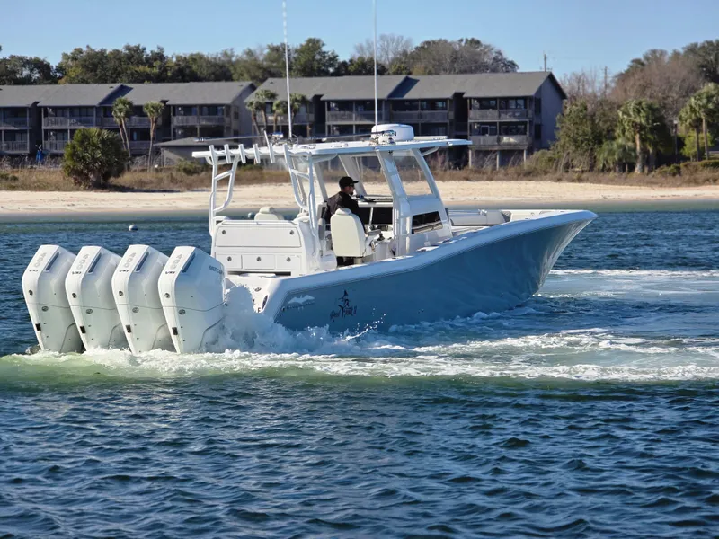 Slide: The Image of 2024 Invincible 43 Open Fisherman boat cruising near the shore with four engines. - 22