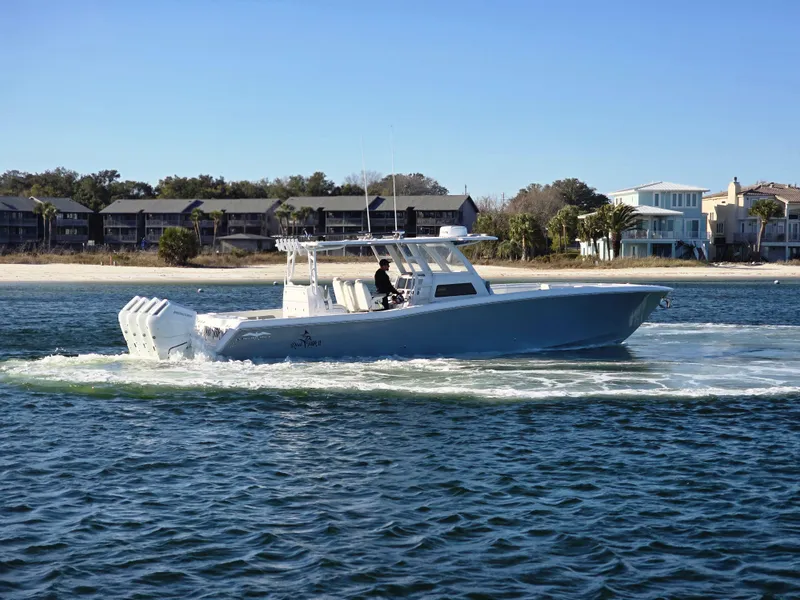 Slide: The Image of 2024 Invincible 43 Open Fisherman boat cruising near a scenic shoreline. - 23