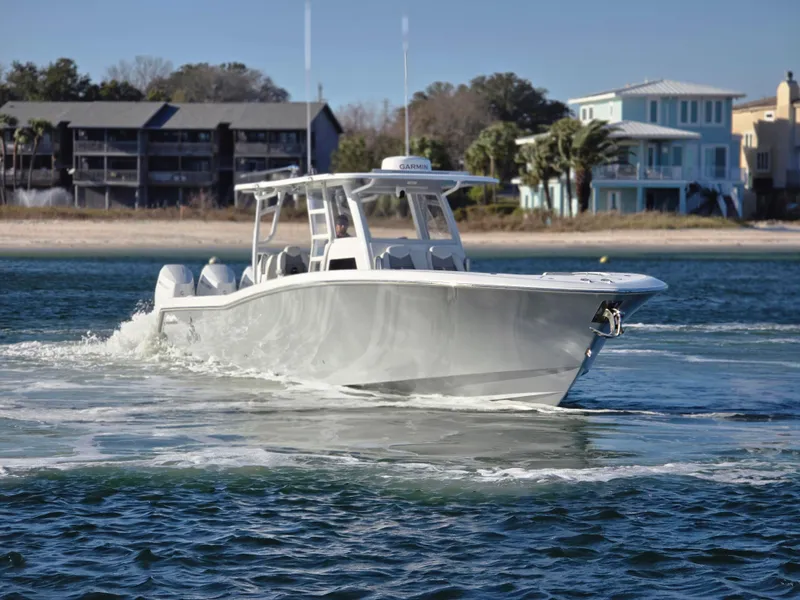 Slide: The Image of 2024 Invincible 43 Open Fisherman boat cruising near a coastal shoreline. - 24