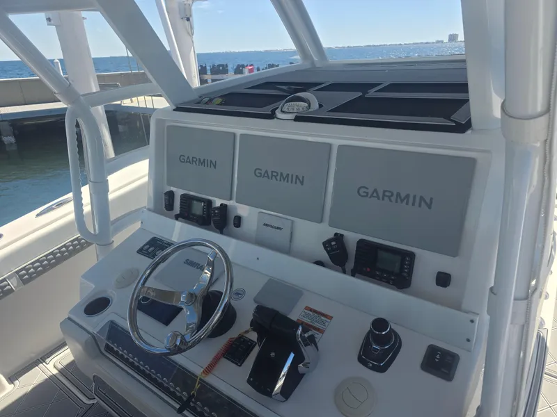 Slide: The Image of 2024 Invincible 43 Open Fisherman boat dashboard with Garmin navigation displays. - 7