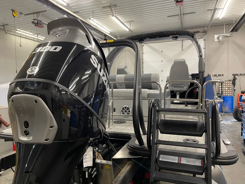 Slide: The Image of 2025 Bentley Pontoons Elite 253 Swingback Tower with Suzuki 300 engine in a garage. - 6