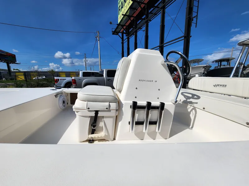 Slide: The Image of 2020 Hewes Redfisher 18 boat interior with steering console and seating under clear blue sky. - 12