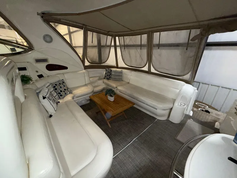Slide: The Image of Interior of 2000 Sea Ray 510 Sundancer yacht with white seating and wooden table. - 12