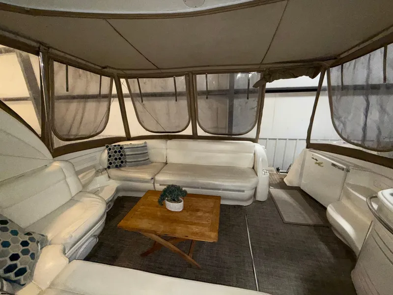 Slide: The Image of Interior of 2000 Sea Ray 510 Sundancer with white seating and wooden table. - 13