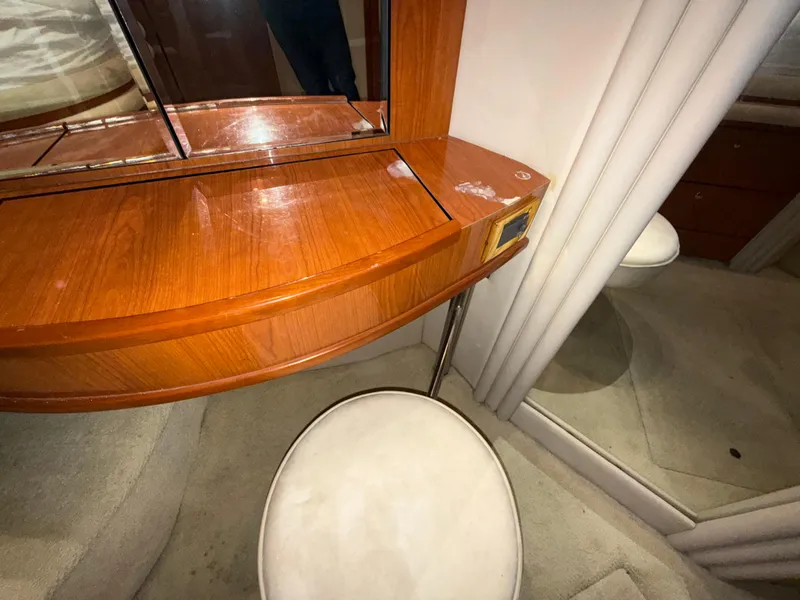Slide: The Image of Interior of 2000 Sea Ray 510 Sundancer with wooden vanity and cushioned stool. - 31